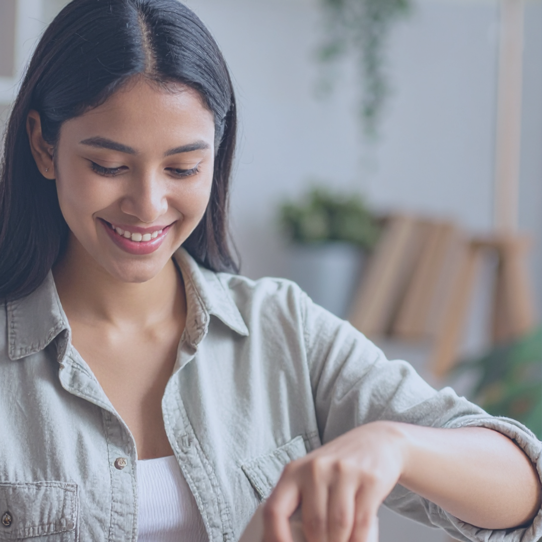 Woman smiling opening package of supplements